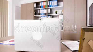 空的办公室内部，桌上有一台高档笔记本电脑